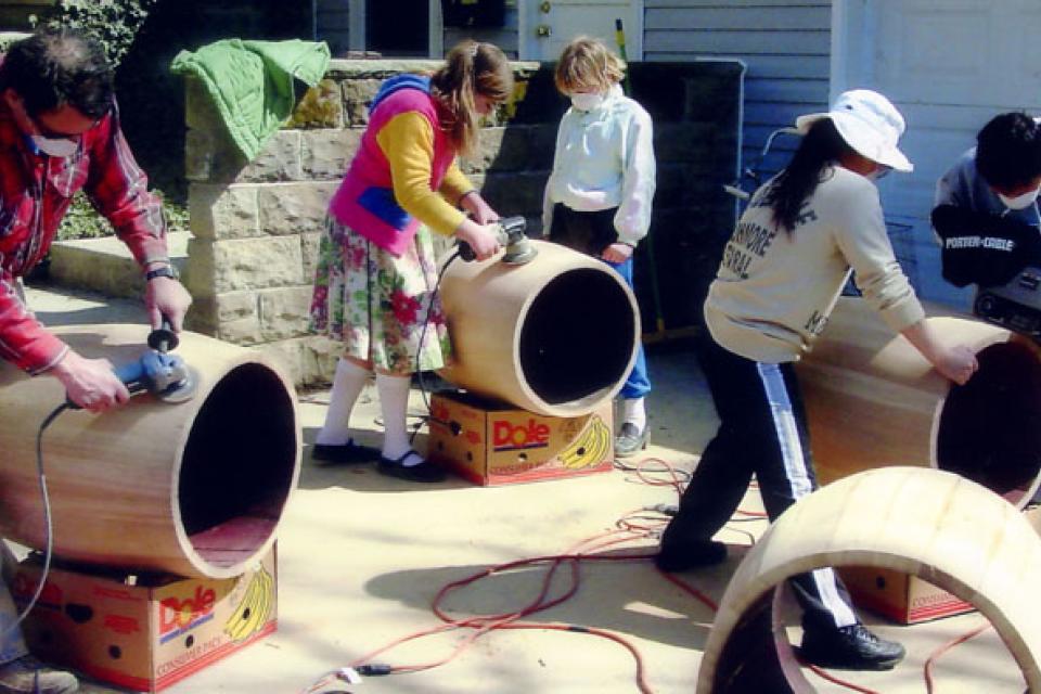 Members of Icho Daiko group sand the drum bodies